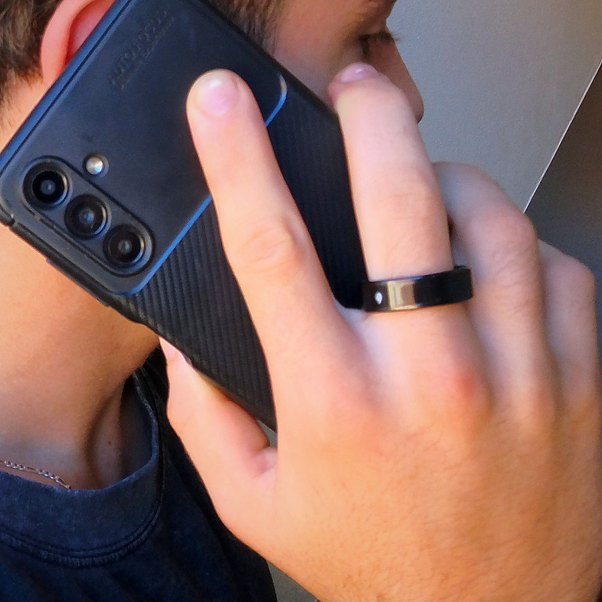Bague connectée noire portée pendant un appel téléphonique, écran éteint